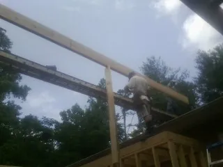 Carpenter setting a ridge beam over a new addition frame — Ice Dam Removal by Roofing Brothers in Weedsport