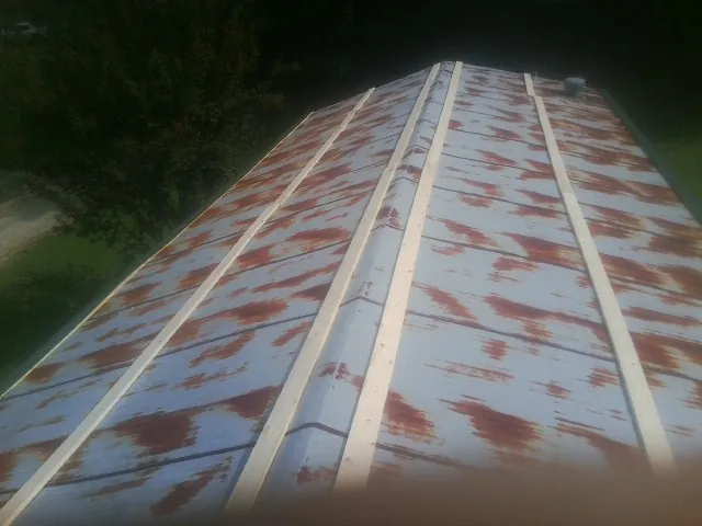 Rusted metal roof panels with new wood purlins before replacement — Storm Damage Roof Repair in Weedsport by Roofing Brothers